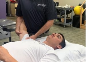Physical therapist Bob Griffin treating young male patient for shoulder pain